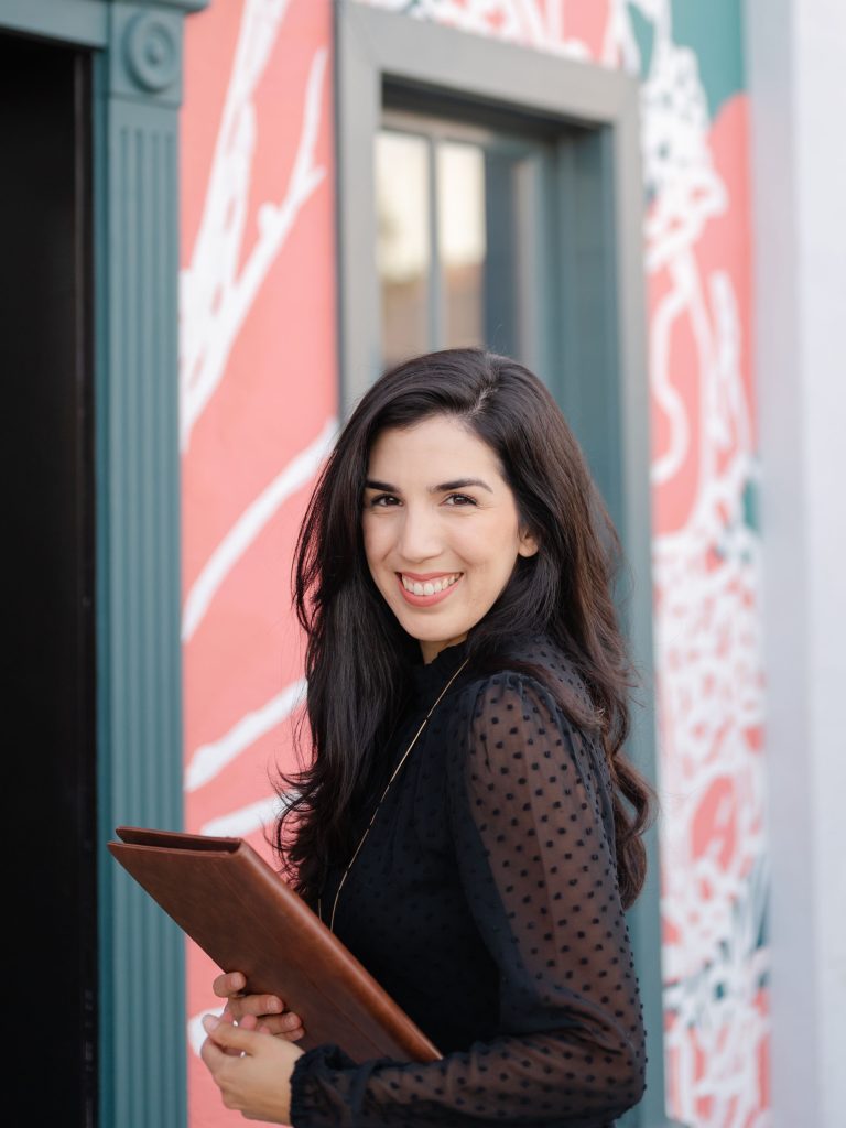 Professionally dressed woman smiling with notebook